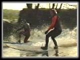 Steve carvin to tha camera, with Dave tucked against the bank